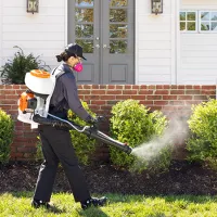 Insect treatment being sprayed around perimeter of home